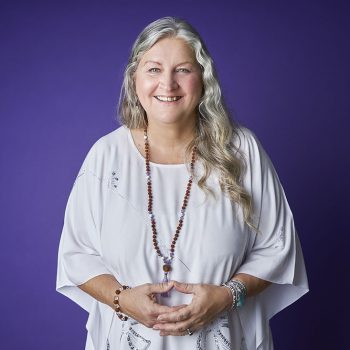 headshot of life coach with purple background